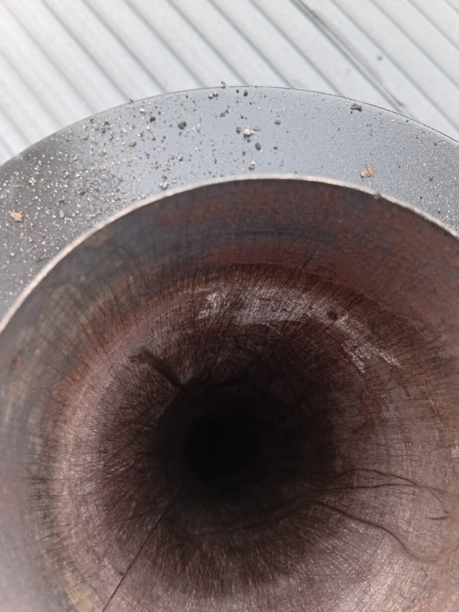 The same chimney flue swept back to bare metal, brush marks visible